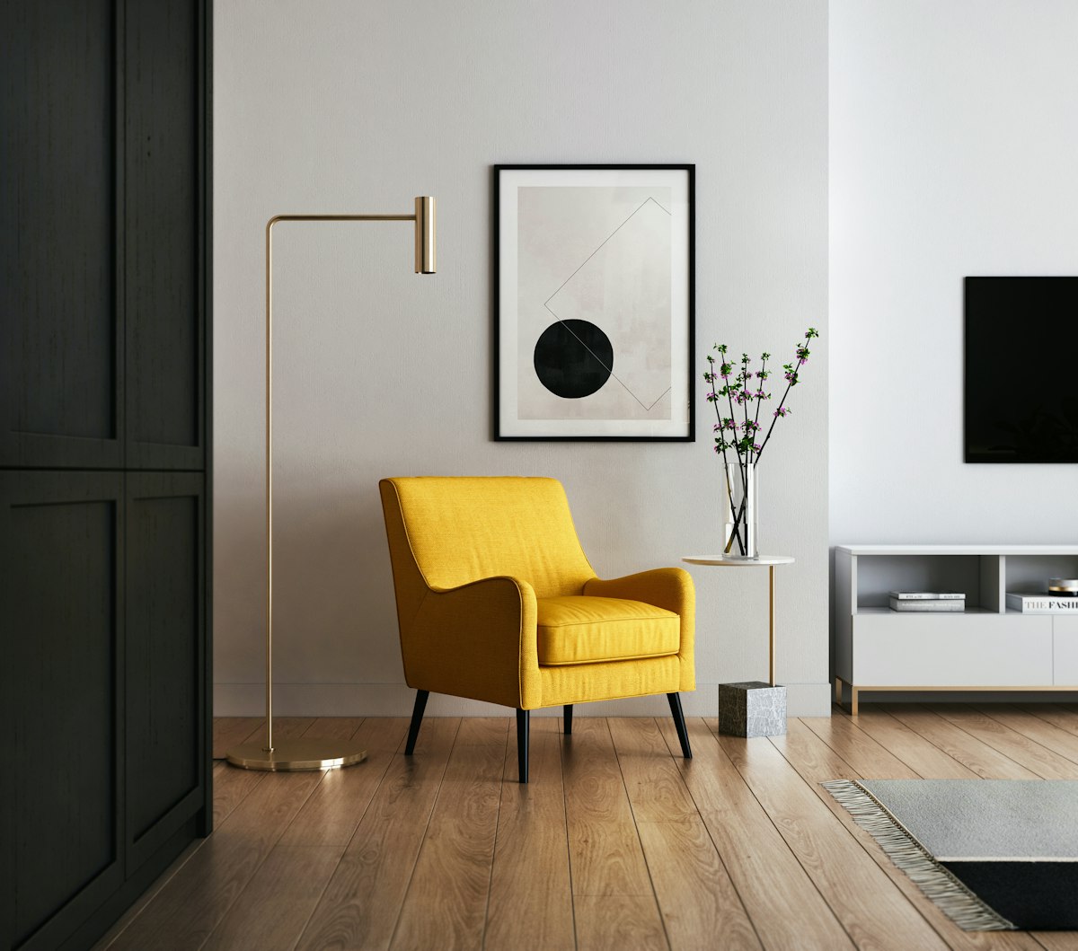 A mustard armchair beside a brass floor lamp and framed abstract artwork